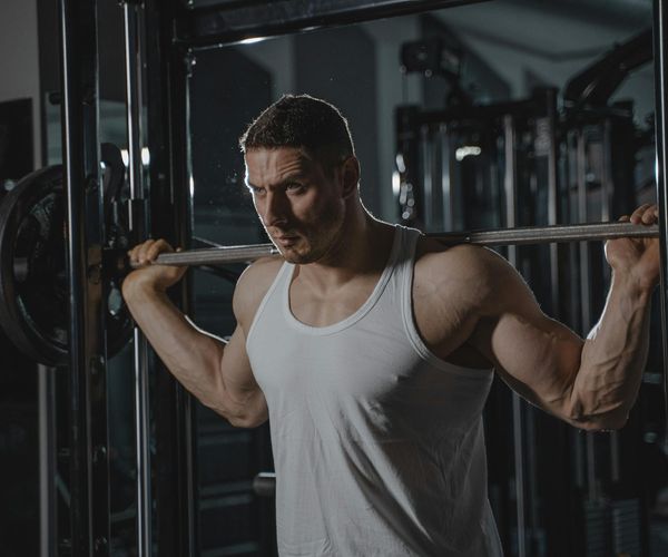 Focused man lifting weights with proper form in a stylish gym.