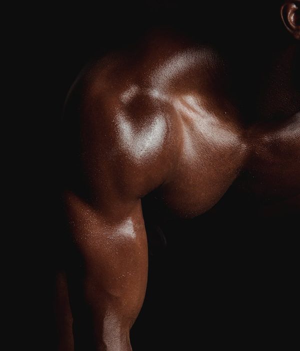 Man performing a controlled strength exercise in a dark gym.